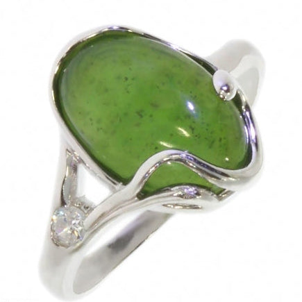 A silver ring featuring a large, polished green cabochon gemstone with tiny inclusions, held in a wavy setting with a small clear accent stone on the band, shown against a plain white background.